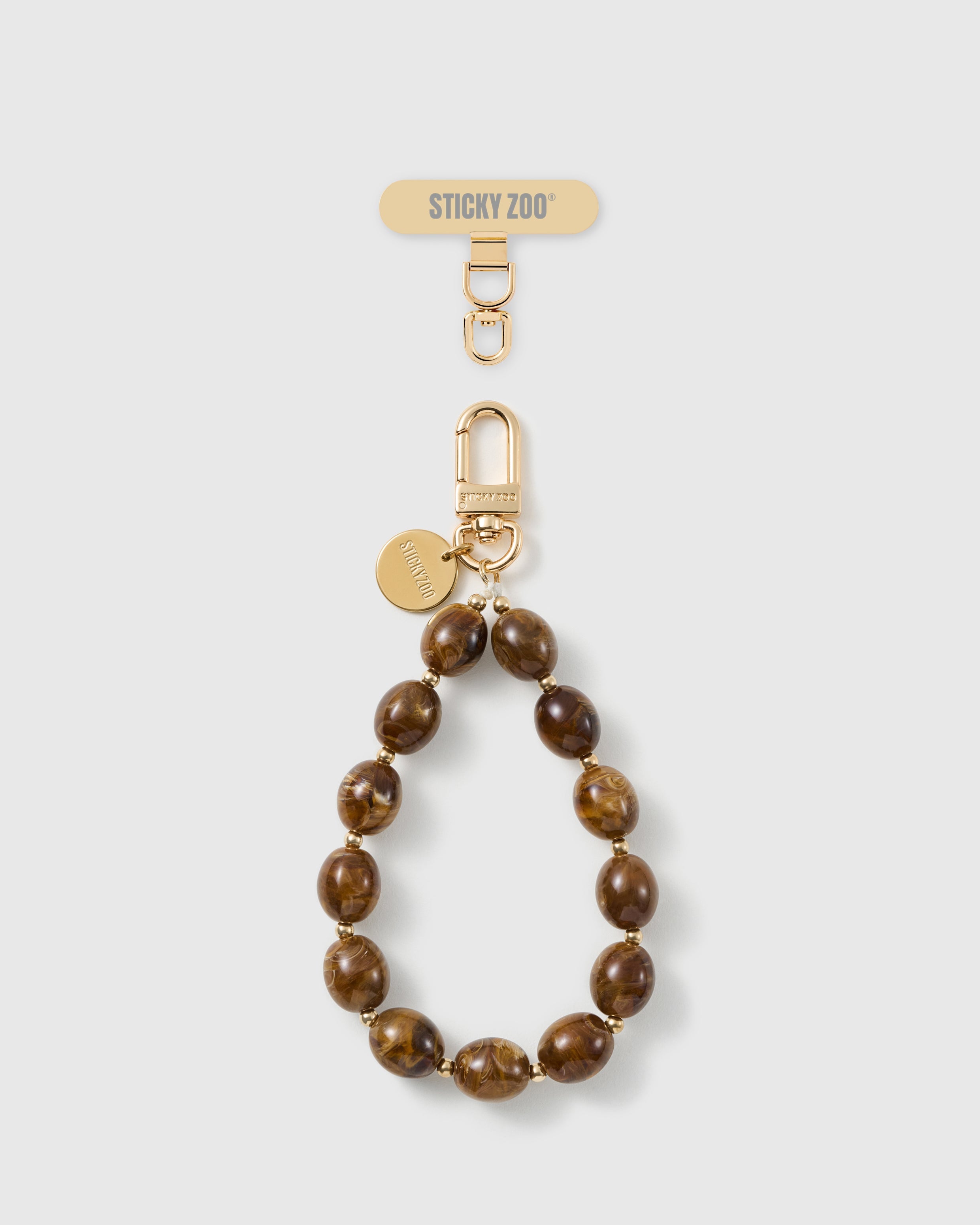 Handmade amber swirl beaded phone strap by STICKYZOO with 18K gold-plated engraved hardware