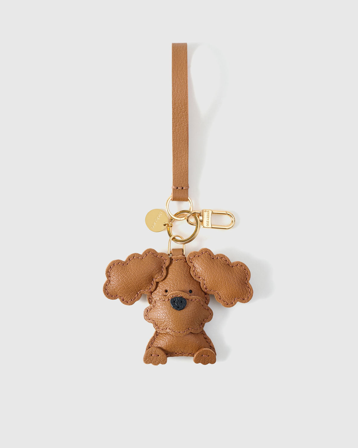 Close-up of handmade Poodle leather bag charm — hand-layered droopy ears in French Alran goatskin. STICKYZOO.