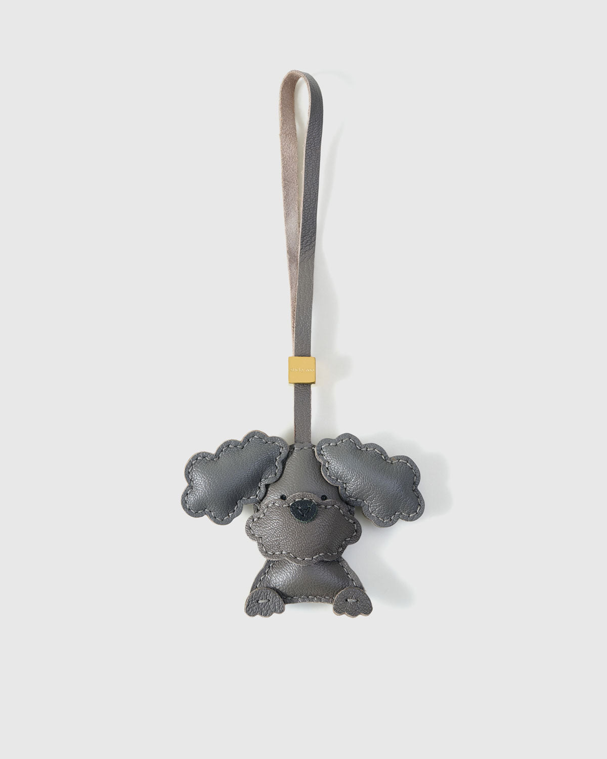 Handmade Poodle leather bag charm — full-grain French Alran goatskin with visible hand-stitched edges. STICKYZOO Amsterdam design.