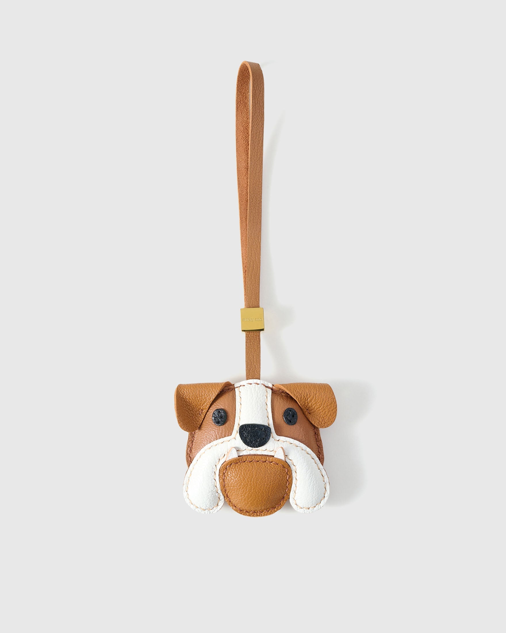 Handmade Bulldog leather bag charm by STICKYZOO — hand-cut, hand-stitched French Alran goatskin in tan with white muzzle over 3 days. Designed in Amsterdam.