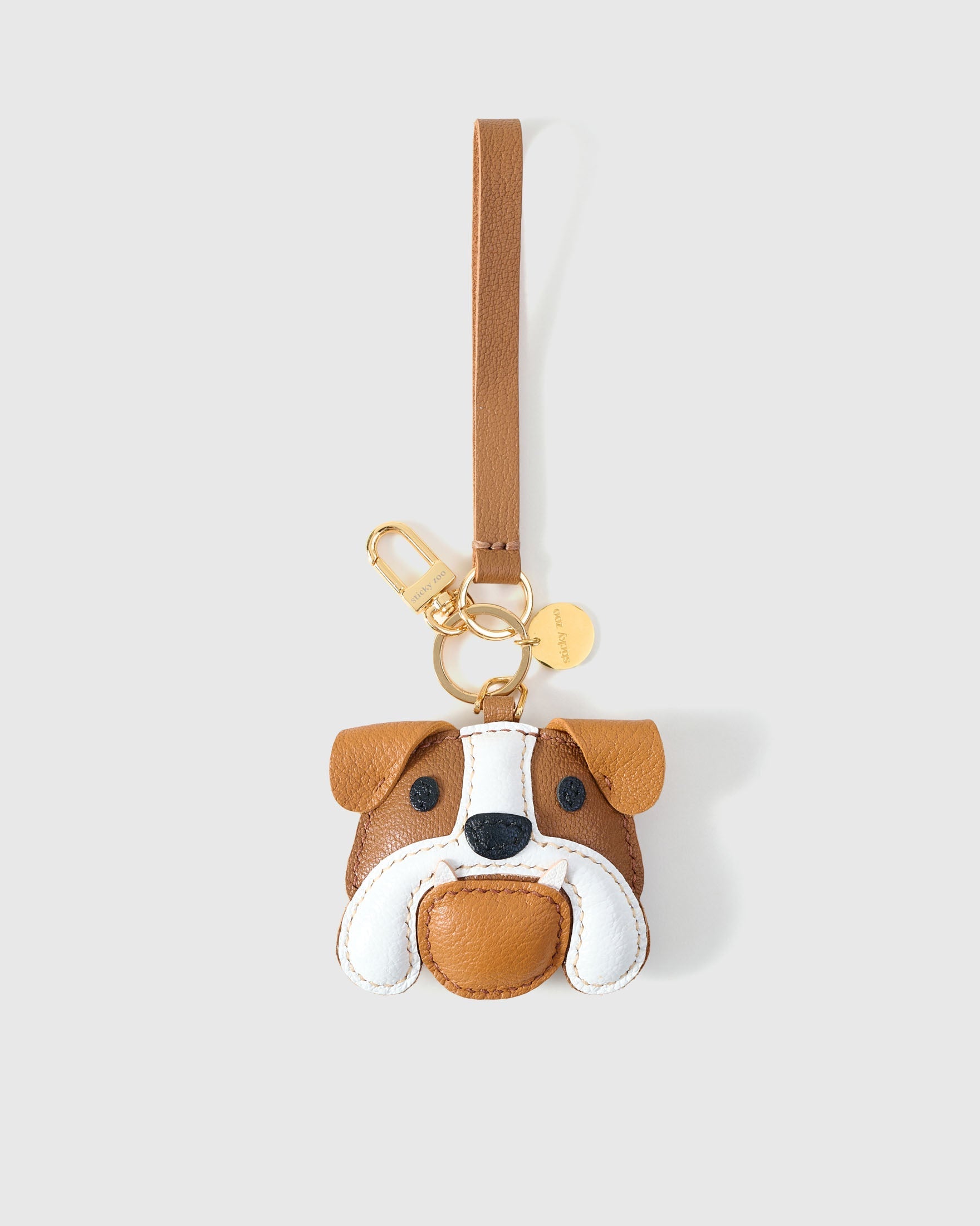 Handmade Bulldog leather bag charm clipped to a handbag — French Alran goatskin, 3-day artisan build. STICKYZOO.