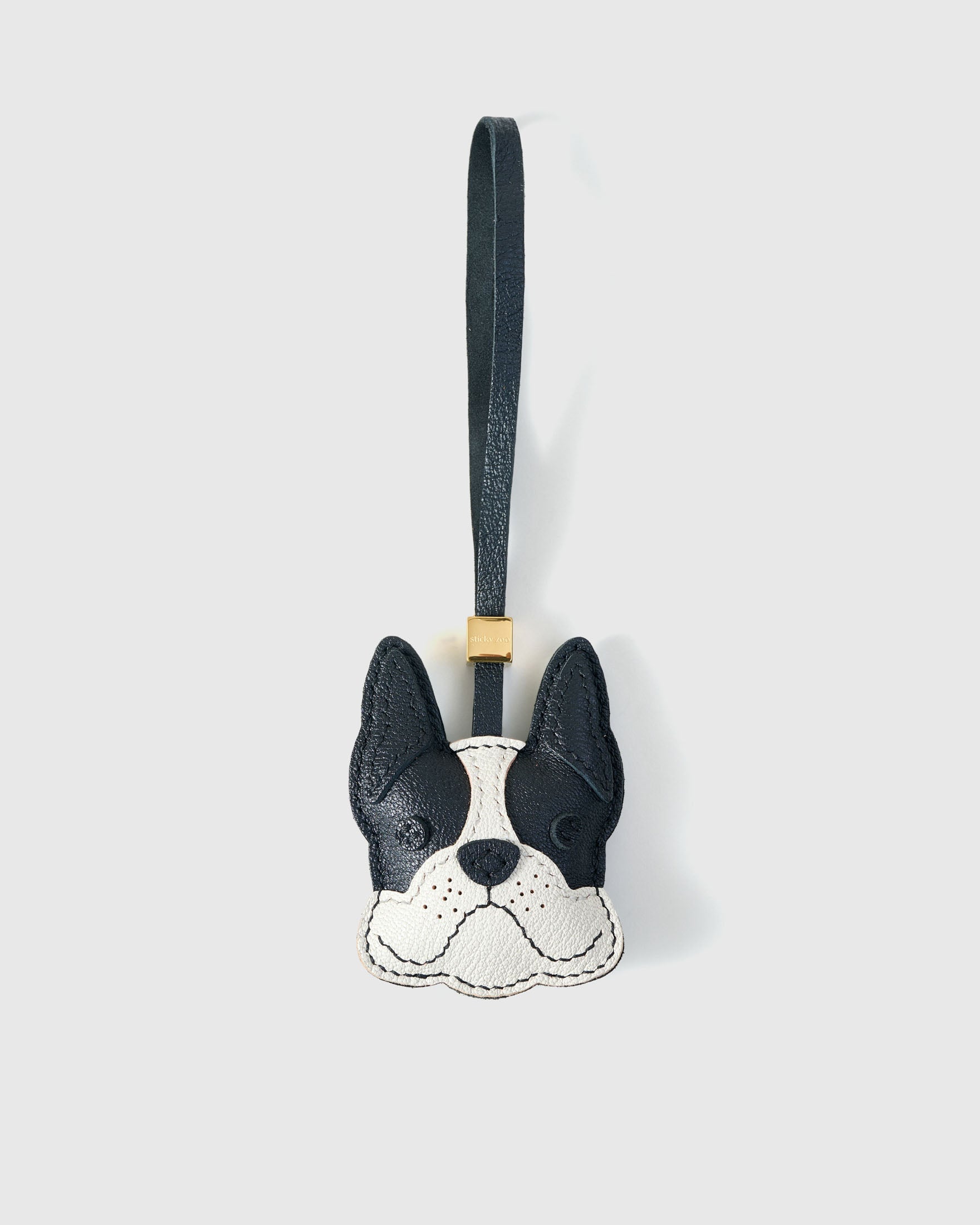 Handmade French Bulldog leather bag charm by STICKYZOO — hand-cut, hand-stitched French Alran goatskin in black with white muzzle over 3 days. Designed in Amsterdam.