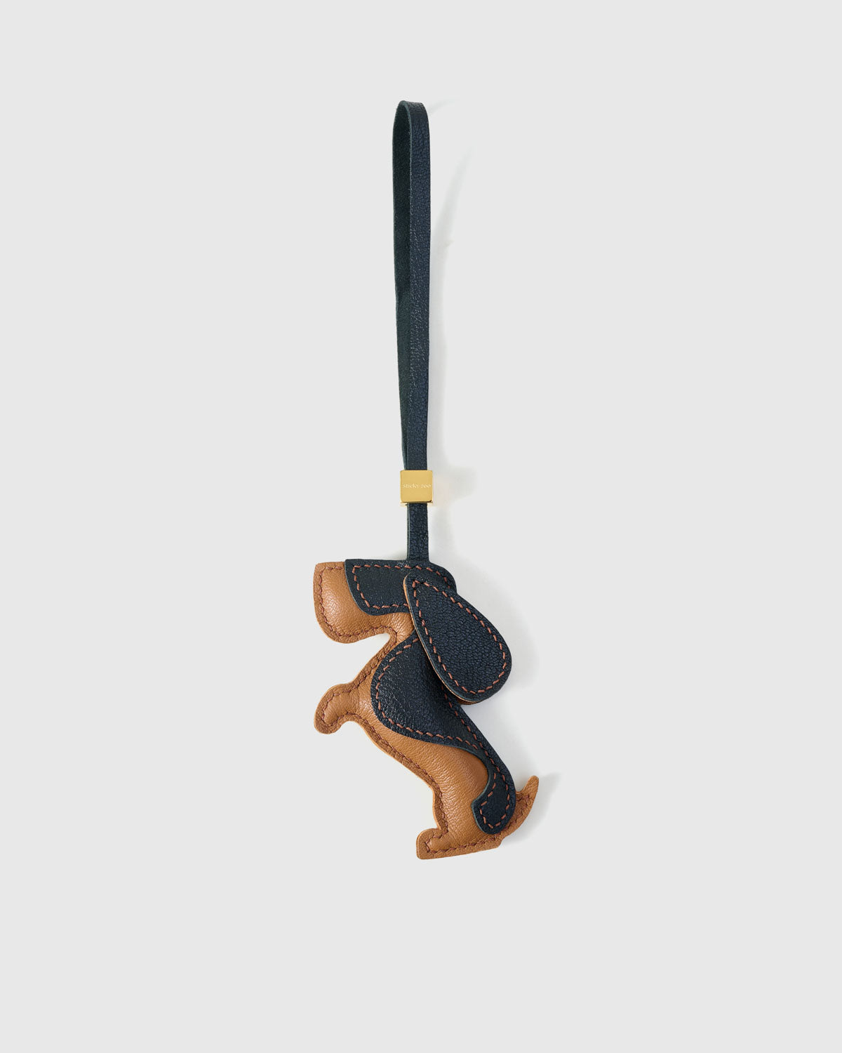 Dachshund charm handmade from French Alran genuine goatskin and French suede — real full-grain leather from Tarn, since 1903. 5 days of hand-cutting, hand-stitching, hand-layering. Arrives in luxury gift packaging. Designed in Amsterdam.