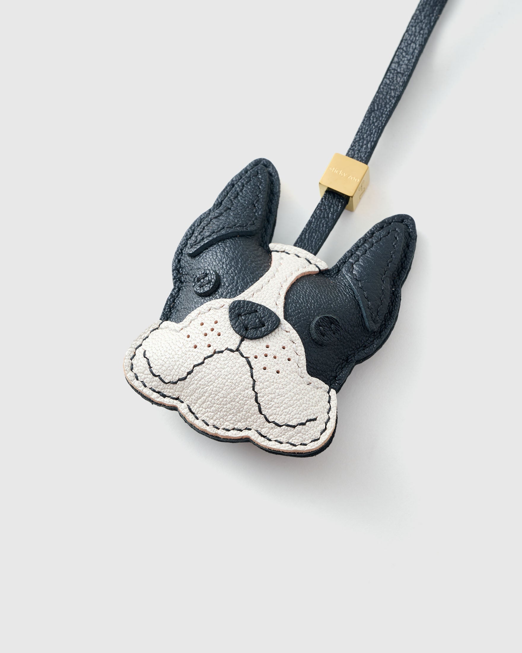 French Bulldog leather bag charm shown in both attachment options — handmade French Alran goatskin, dual attachment. STICKYZOO Amsterdam design.