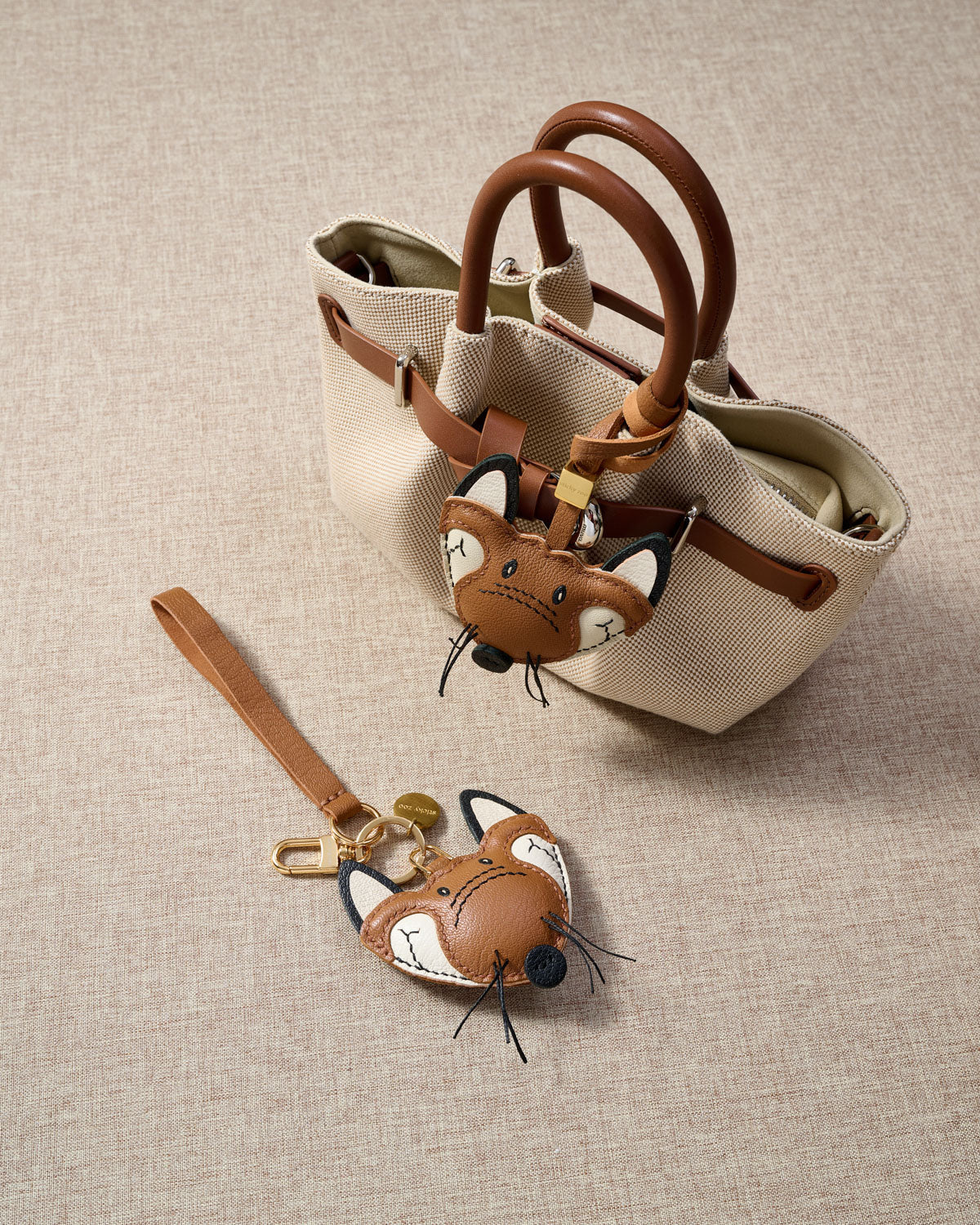 Close-up of the fox charm — hand-cut and hand-stitched panels of French Alran goatskin. Every layer by hand.