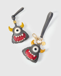 Both editions of the little monster — leather strap loop for bags, or 18K gold-plated keychain clip.