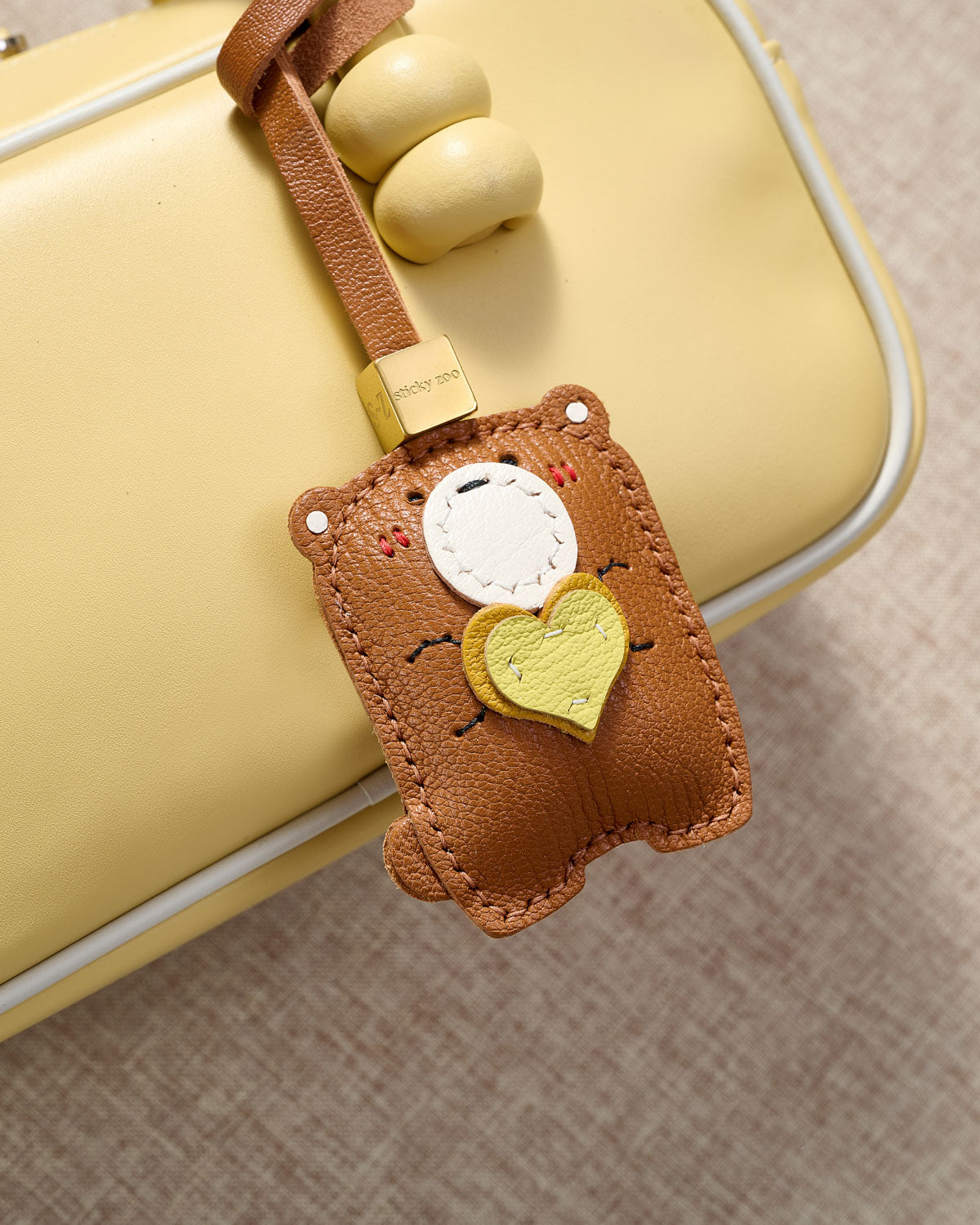 TEDDY BEAR CHARM charm styled on a bag — a small, specific piece that turns a simple bag into a personal one.