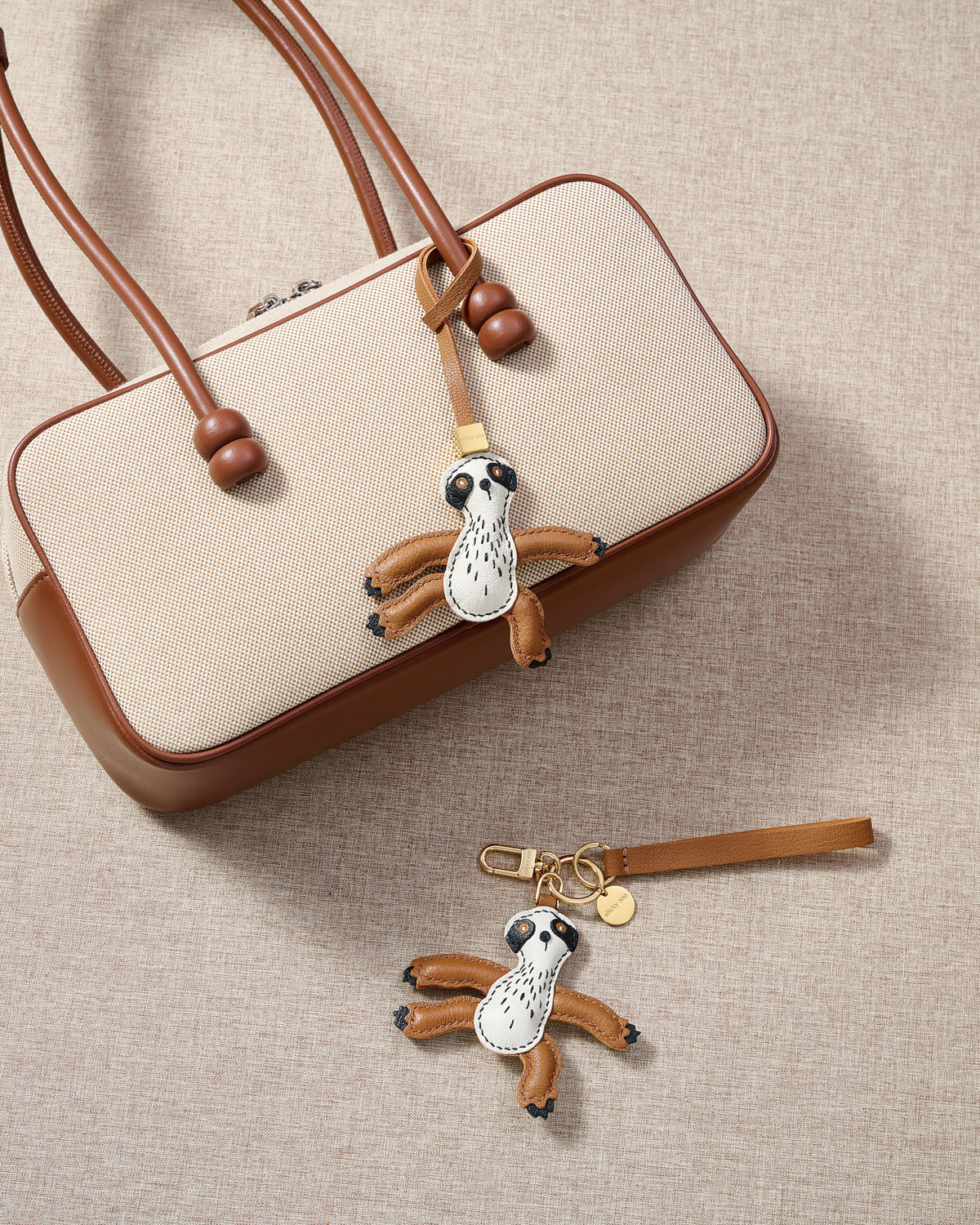 Close-up of the sloth charm — hand-cut and hand-stitched panels of French Alran goatskin. Every layer by hand.