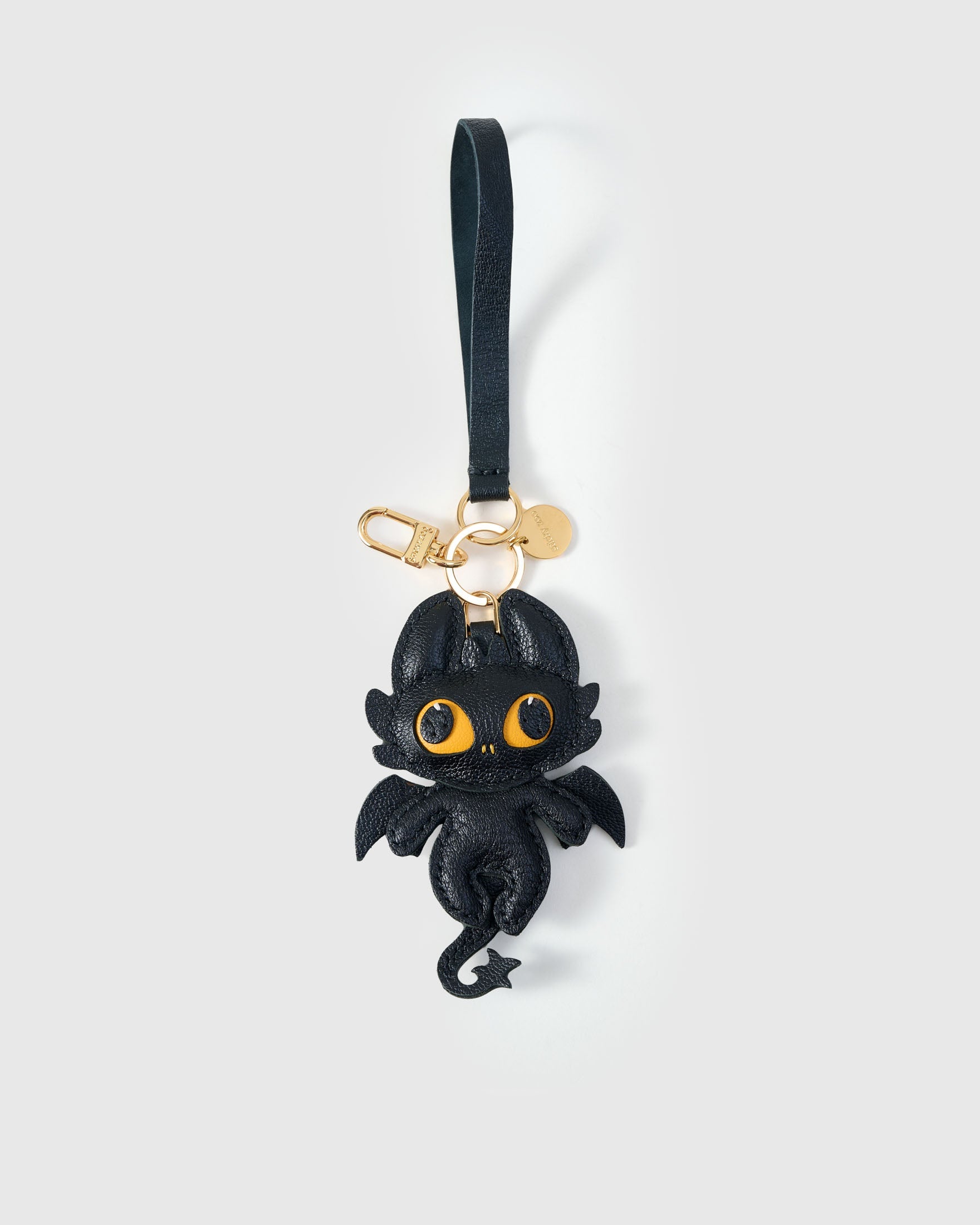 Both editions of the black dragon — leather strap loop for bags, or 18K gold-plated keychain clip.