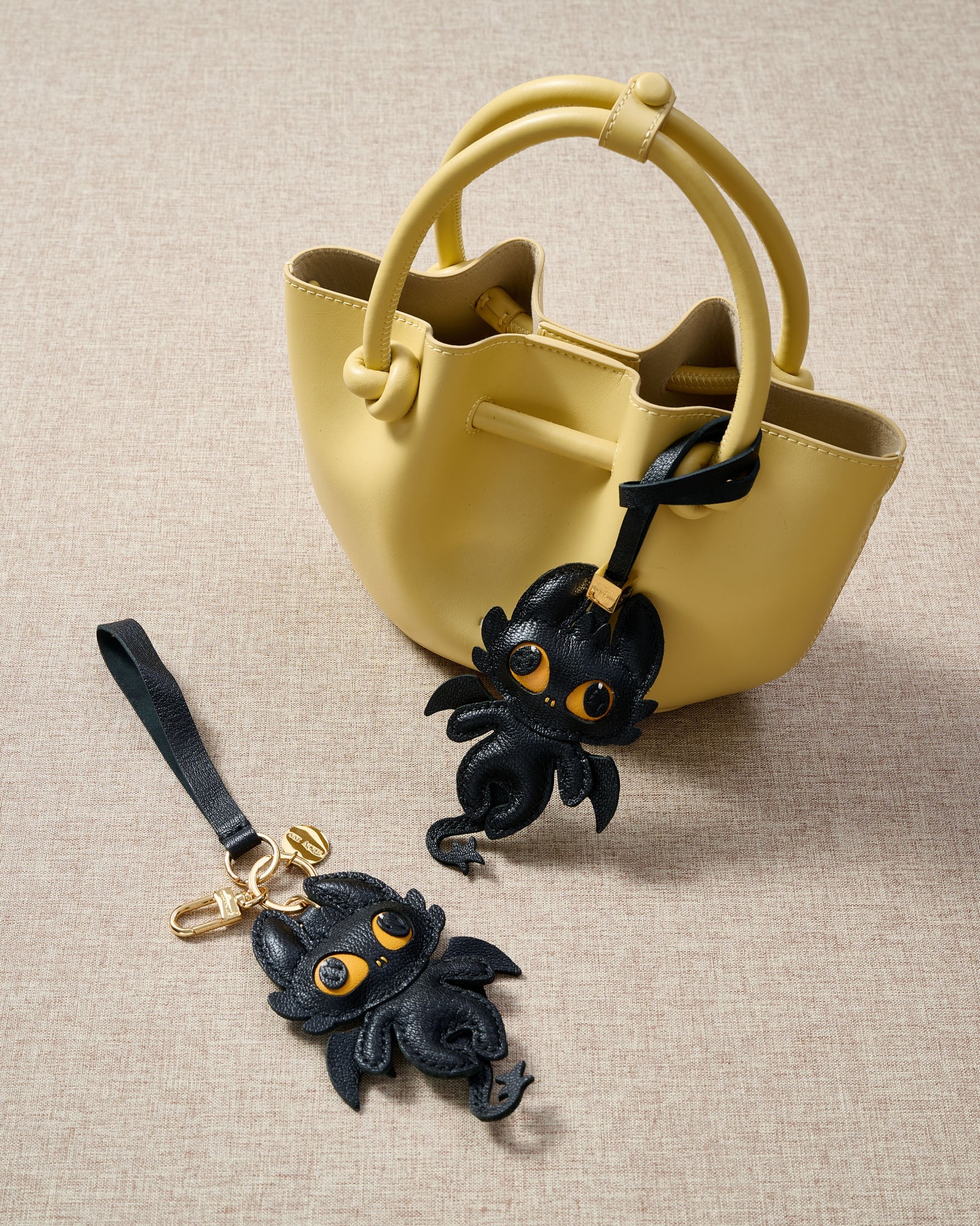 Black dragon charm styled on a bag — a small, specific piece that turns a simple bag into a personal one.