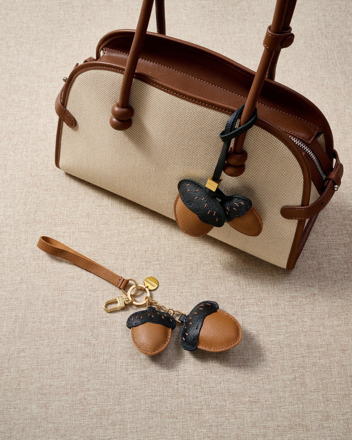 Close-up of STICKYZOO Acorns Charm — full-grain French Alran goatskin from Tarn, France. Twin acorn pair with dash stitching. 3-day handmade piece.