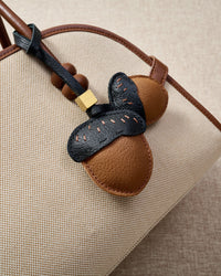 STICKYZOO Acorns Charm — hand-cut, hand-stitched twin acorn pair with dash stitching in French Alran goatskin. Designed in Amsterdam.