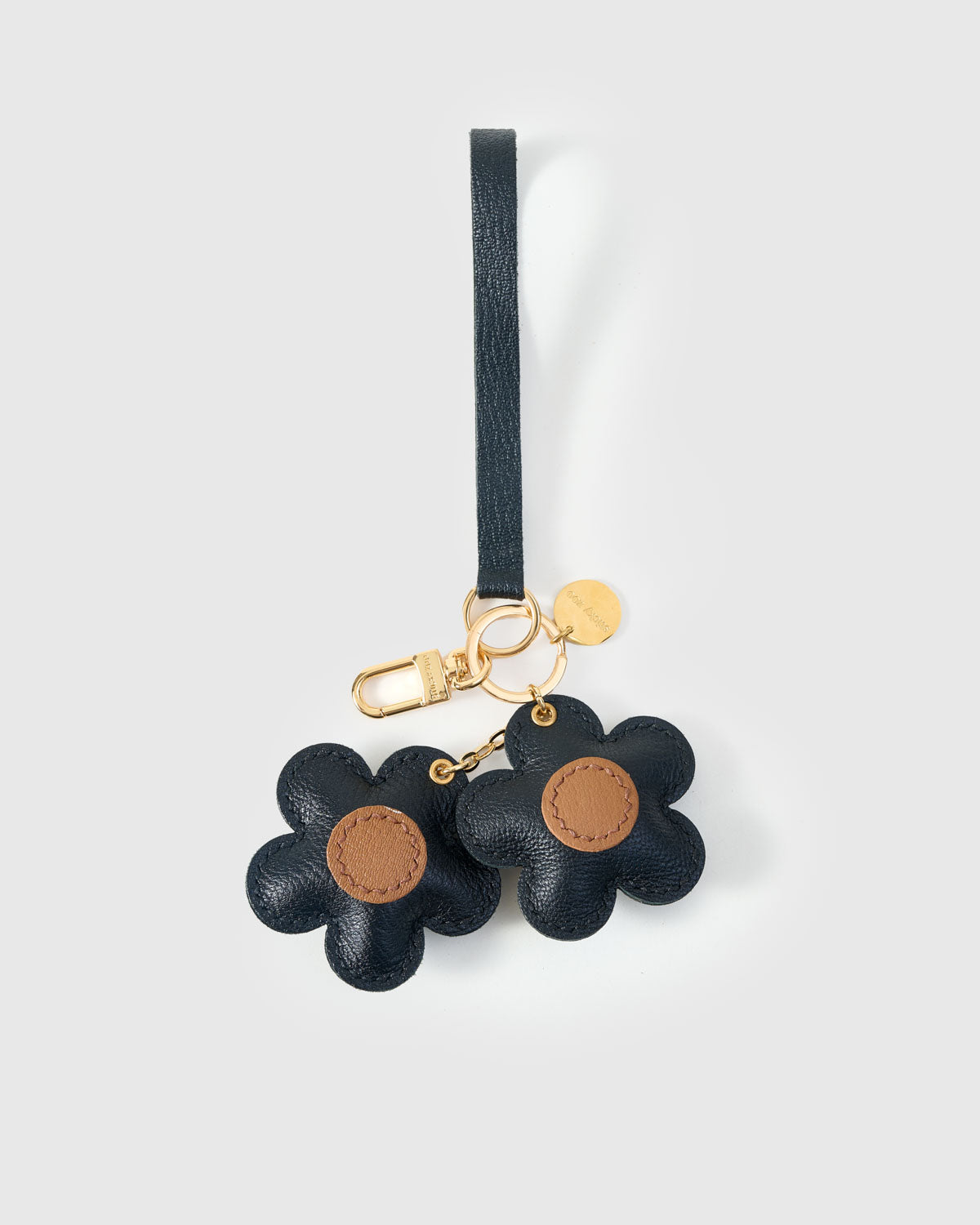 STICKYZOO Twin Flowers Charm clipped to a handbag — handmade French Alran goatskin in taupe with olive centres. 3-day artisan build.