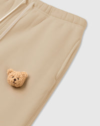 Detail of bear applique on STICKYZOO cream Sticky Bear Sweatpant showing tonal warmth