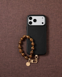 Amber swirl bead phone strap styled on fabric, loved by thousands of STICKYZOO customers